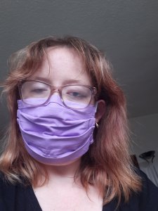 A photo of me with messy lockdown hair, wearing a purple face covering.